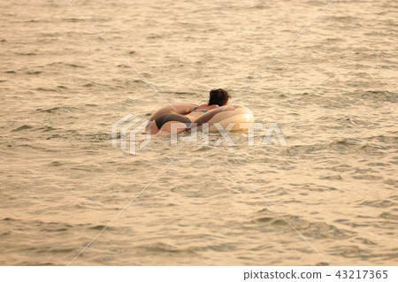 Real woman swimming with inflatable ring in sea, copyspace Real woman swimming with inflatable ring in sea, copyspace 43217365