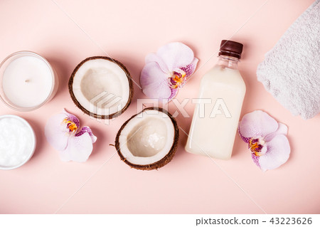 Coconut oil and halves of fresh coconut on a pink background. Hair care spa concept 43223626