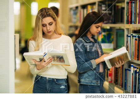 Happy young girls student studing in library Happy young girls student studing in library 43227881