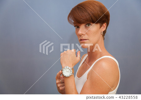 The young woman shows the time on her watch The young woman shows the time on her watch 43228558