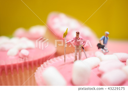 Miniature golfer on pink cake 43229175