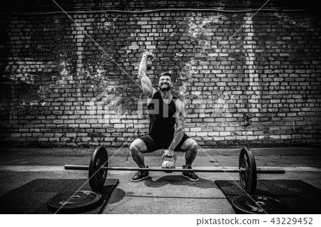 Athletic man working out with a kettlebell. Strength and motivation Athletic man working out with a kettlebell. Strength and motivation 43229452