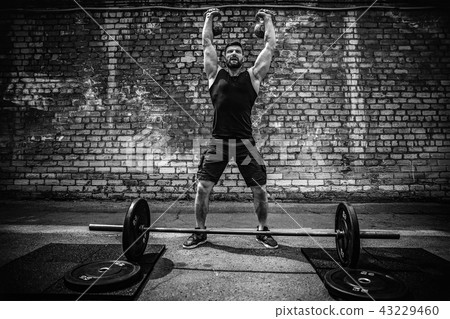 Athletic man working out with a kettlebell. Strength and motivation Athletic man working out with a kettlebell. Strength and motivation 43229460
