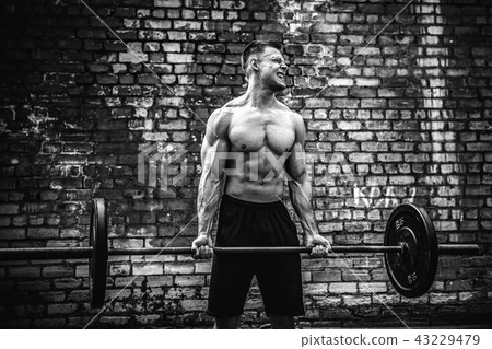 Muscular fitness man doing deadlift a barbell over his head in outdoor, street gym. Functional 43229479