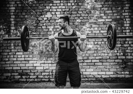 Muscular fitness man doing deadlift a barbell over his head in outdoor, street gym. Functional Muscular fitness man doing deadlift a barbell over his head in outdoor, street gym. Functional 43229742