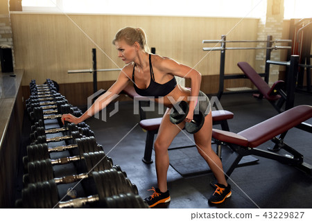 Fitness girl lifting dumbbell 43229827