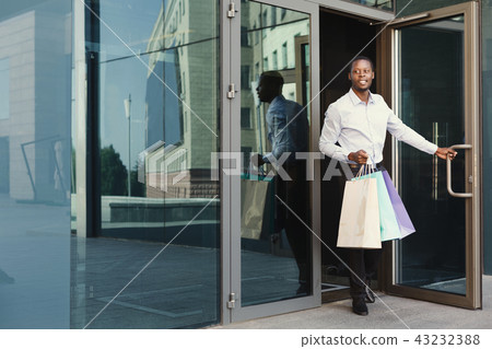 Black businessman carrying shopping bags 43232388