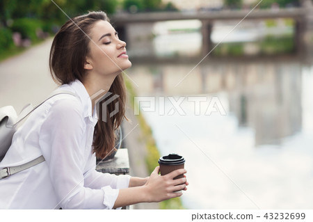 Young beautiful girl standing near city waterfront Young beautiful girl standing near city waterfront 43232699