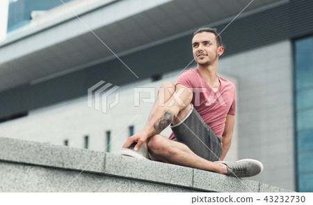 Tattooed man doing yoga asana on street Tattooed man doing yoga asana on street 43232730