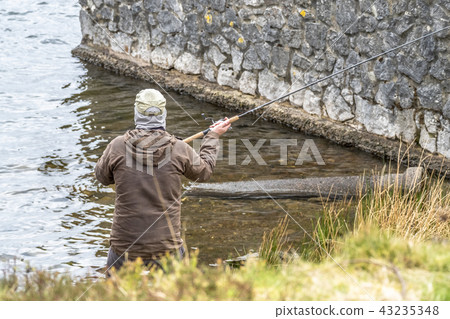 Man fishing on the beach of Llyn Ogwen, Wales - UK Man fishing on the beach of Llyn Ogwen, Wales - UK 43235348