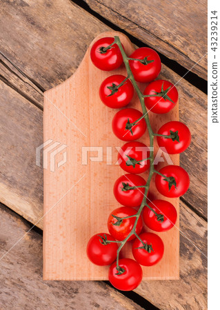 Stem of cherry tomatoes on wooden board. Stem of cherry tomatoes on wooden board. 43239214