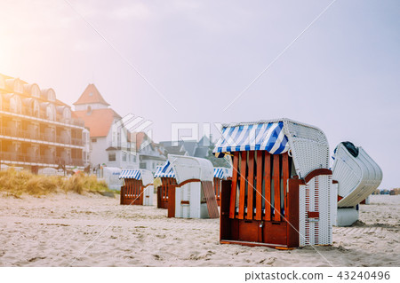 Blue striped roofed chairs on sandy beach near resort Travemunde in sun light in low season. Germany Blue striped roofed chairs on sandy beach near resort Travemunde in sun light in low season. Germany 43240496