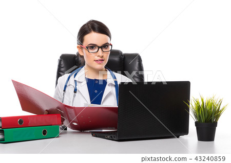 Young woman doctor with stethoscope sitting on the desk at medical office in white uniform on white 43240859