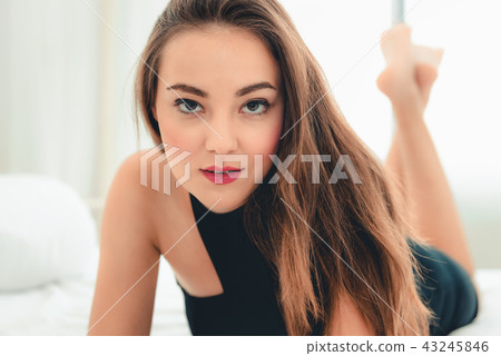 Portrait of beautiful woman lying on her bedroom 43245846
