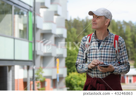 Tourist with backpack and mobile phone Tourist with backpack and mobile phone 43246863