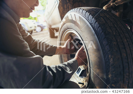 The car repairer checking the car for maintenance The car repairer checking the car for maintenance 43247166