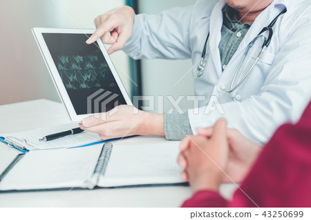 Doctor consulting with patient results x-ray film Doctor consulting with patient results x-ray film 43250699