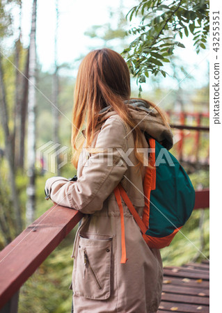 Girl traveler standing on forest bridge  43255351
