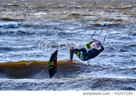 A male kiteboarder jumps above the surface A male kiteboarder jumps above the surface 43257195