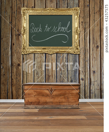 old wooden chest and golden antique frame at wall 43257575