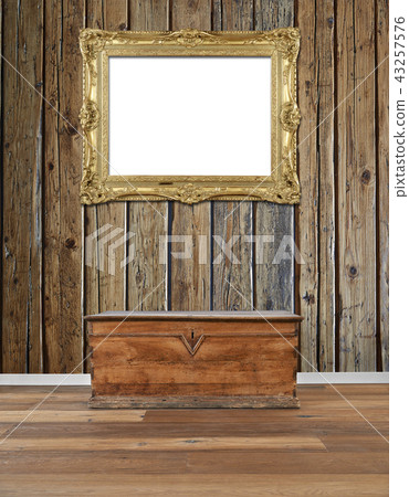 old wooden chest and golden antique frame at wall 43257576