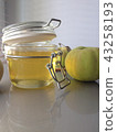 a honey jar and an apple on a light background 43258193