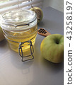 a honey jar and an apple on a light background 43258197
