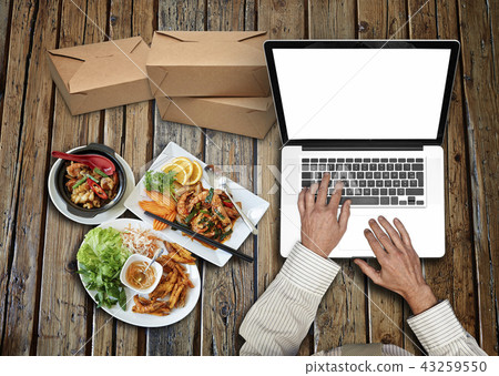 Working on his laptop on rustic wooden table Working on his laptop on rustic wooden table 43259550