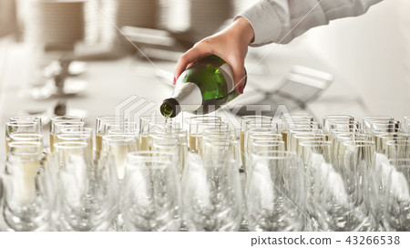Waiter pouring champagne into glasses at party Waiter pouring champagne into glasses at party 43266538