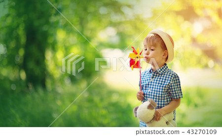 Baby boy standing in grass on the fieald with windmill Baby boy standing in grass on the fieald with windmill 43270109