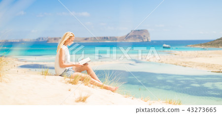 Woman reading book, enjoying sun on beach. Woman reading book, enjoying sun on beach. 43273665