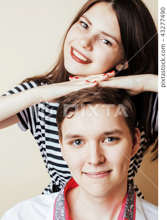 couple of happy smiling teenagers students, warm colors having a couple of happy smiling teenagers students, warm colors having a 43277490