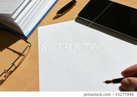 Hand writing pen on a sheet of paper on a desktop Hand writing pen on a sheet of paper on a desktop 43277846
