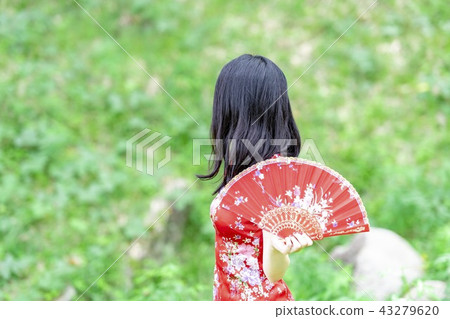 A woman in a Chinese dress standing in the forest A woman in a Chinese dress standing in the forest 43279620