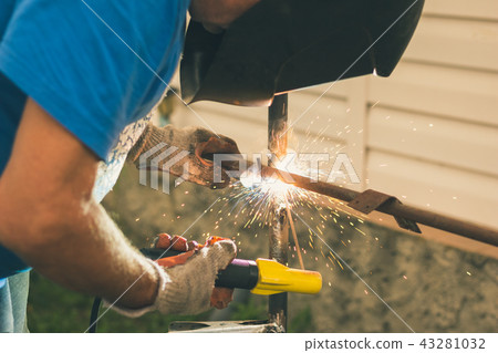 Man works as an electric welder his summer cottage 43281032
