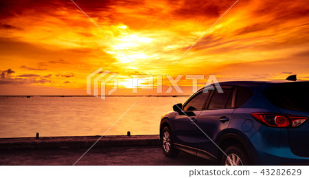Blue SUV car parked on concrete road by the sea Blue SUV car parked on concrete road by the sea 43282629