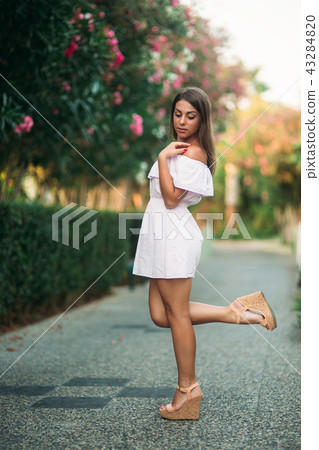 Sexy lady in white dress standing near the flowers 43284820