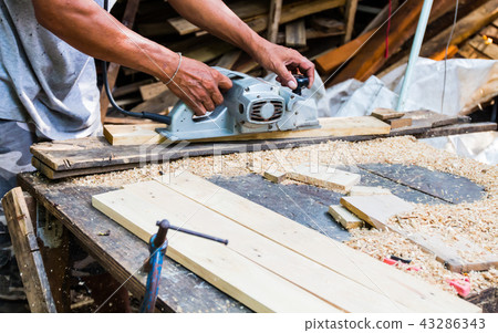 Man using a grinding machine on wood Man using a grinding machine on wood 43286343