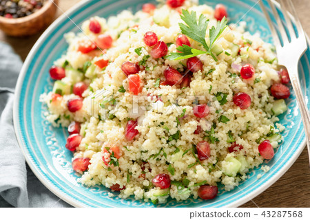 Tabbouleh salad with pomegranate seeds on turquoise plate 43287568
