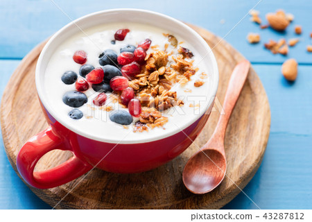 Natural yogurt with honey granola, pomegranate and blueberries 43287812