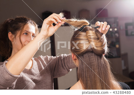 hairdresser making a coiffure to a model 43288480