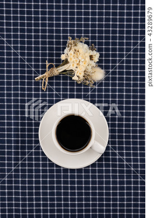 A cup of coffee and white flower bouquet 43289679