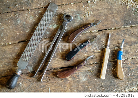 Tools for horseshoe horse hooves. They lie on the wooden floor of the floorboards. Tools for horseshoe horse hooves. They lie on the wooden floor of the floorboards. 43292012