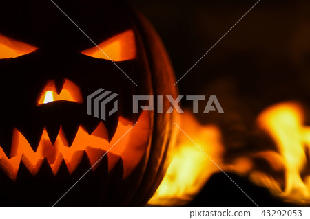 Terrible pumpkin as head of jack-o-lantern with carved eyes and wicked smirk in burning hell fire Terrible pumpkin as head of jack-o-lantern with carved eyes and wicked smirk in burning hell fire 43292053