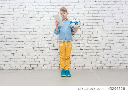 Boy has to decide between homework and football Boy has to decide between homework and football 43296526
