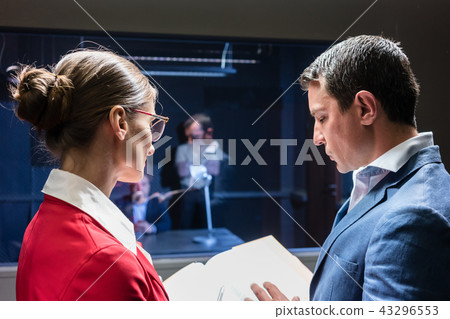 Two police detectives analyzing the files of a criminal case Two police detectives analyzing the files of a criminal case 43296553