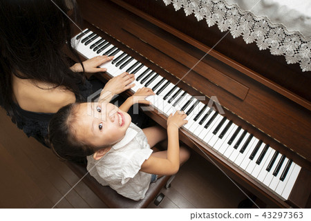 Mother and daughter playing the piano 43297363
