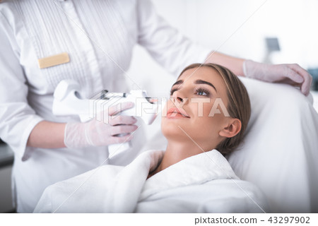 Lovely young woman getting injection in cheek 43297902