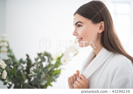 Satisfied woman keeping white bathrobe with arms 43299239
