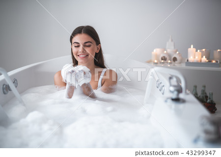 Positive woman entertaining in bath in room Positive woman entertaining in bath in room 43299347